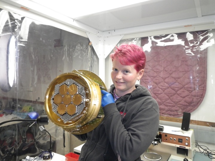 Liz George holding the partially assembled focal plane. The 150 GHz horns are open, while the feedhorns on the 90 GHz pixels are covered in aluminum tape. 