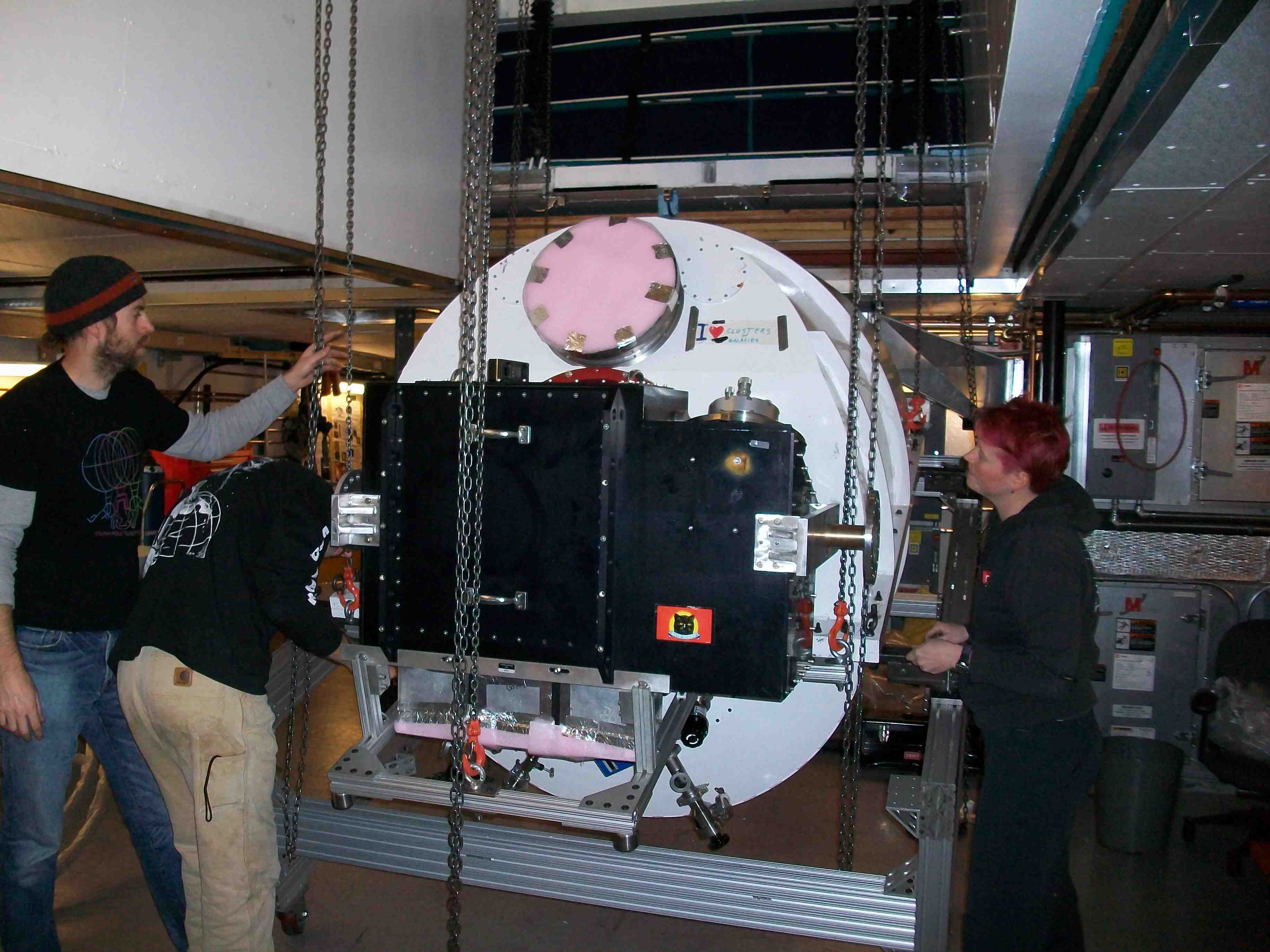The receiver cryostat being mated to the enormous white Optics cryostat.